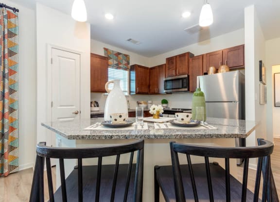 a kitchen with a counter top with two stools at Capstone at Banks Crossing, Commerce, GA