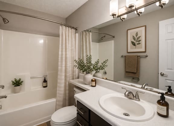A bathroom with a white sink and a white toilet at Southland Station Apartments in Warner Robins, 31088