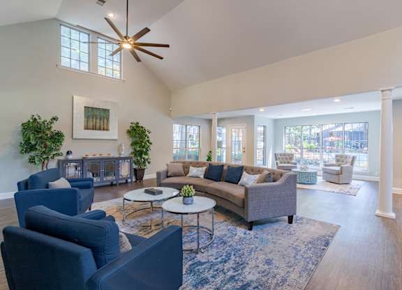 A living room with a grey couch and blue chairs.
