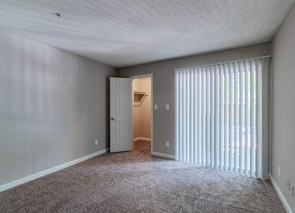 A room with a carpeted floor and a doorway leading to another room.