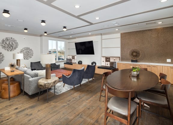 a resident clubhouse with a table and chairs and a couch at The Flats at Southlawn Apartments, Georgia