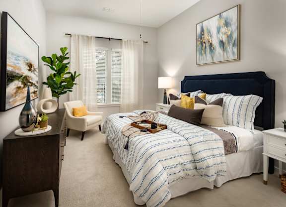 A bedroom with a large bed and a painting on the wall.