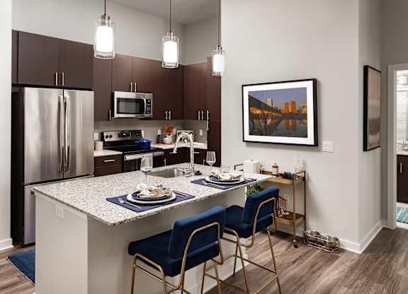 A kitchen with a table and chairs and a fridge.
