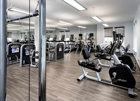 A gym with a variety of equipment including treadmills and weights.