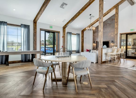 a dining area with a table and chairs and a living room with a fireplace at Farmhaus Apartments, Madison, 35757