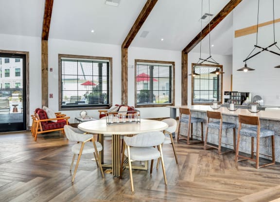 a dining area with a round table and chairs and a window at Farmhaus Apartments, Alabama, 35757