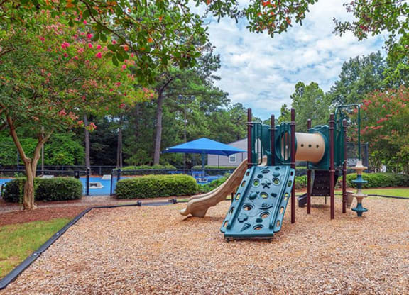 a playground with a swing set and a slide in a park at High Ridge Apartments, Athens, 30606