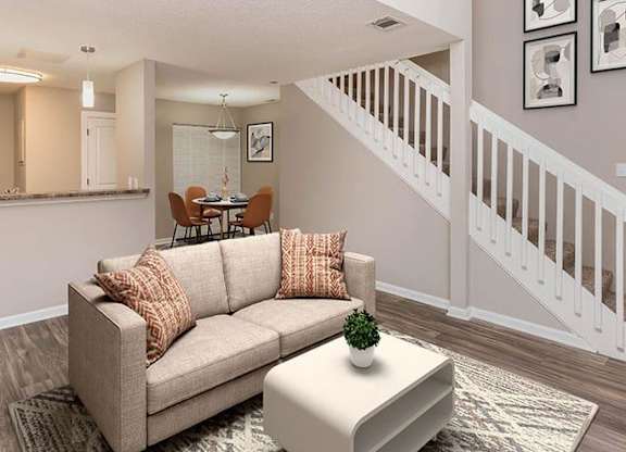 A living room with a couch, a coffee table, and a staircase. at Bradford Pointe, Augusta, 30909