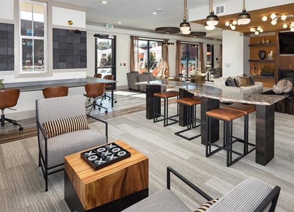 a clubhouse with a bar and a living room with furniture at The Flats at Southlawn Apartments, Lawrenceville, GA