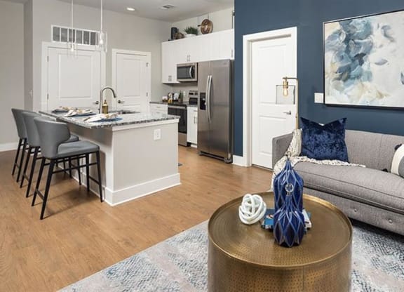 a living room and kitchen with a couch and a table at The Flats at Southlawn Apartments, Lawrenceville Georgia