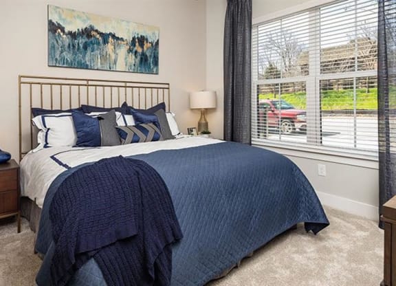 a bedroom with a bed and a window at The Flats at Southlawn Apartments, Lawrenceville Georgia
