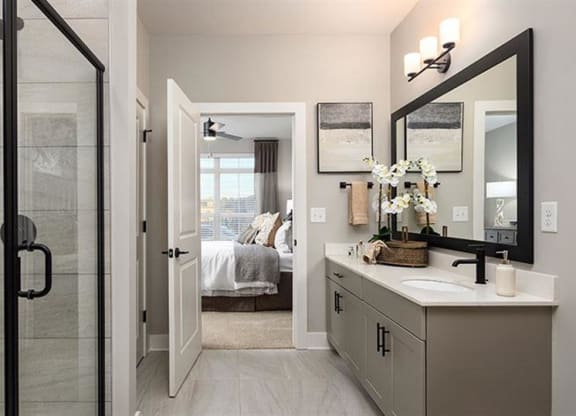 a bathroom with a shower and a sink and a mirror at The Flats at Southlawn Apartments, Lawrenceville, 30046