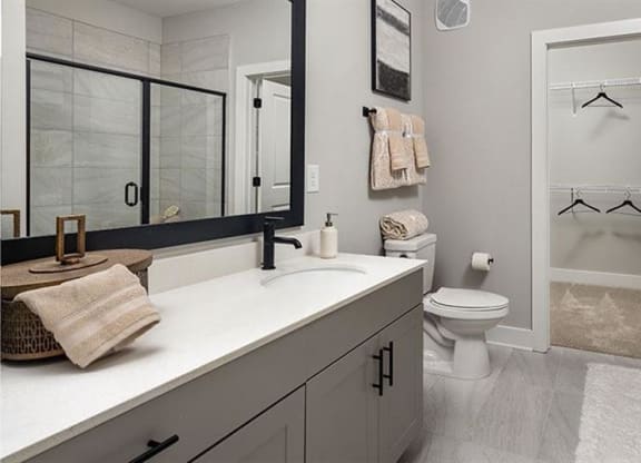 a bathroom with a sink and a toilet and a shower at The Flats at Southlawn Apartments, Lawrenceville, GA