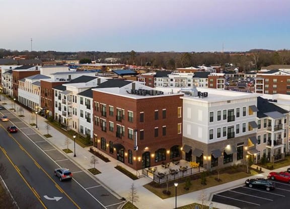 an aerial view of a city street with buildings and cars at The Flats at Southlawn Apartments, Lawrenceville Georgia