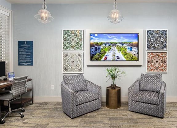 a lobby with two chairs and a tv on the wall at Promenade at Newnan Crossing, Georgia