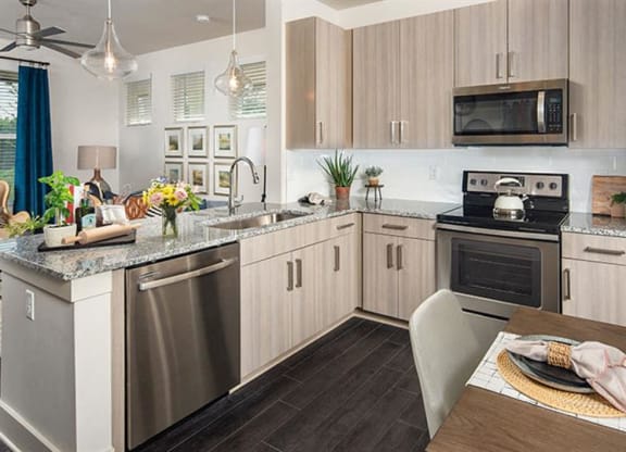 a kitchen with stainless steel appliances and a table at Promenade at Newnan Crossing, Newnan, GA