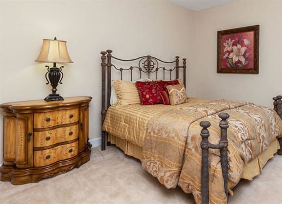 a bedroom with a bed and a dresser at Bedford Parke Apartments, Warner Robins Georgia