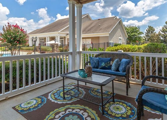 a patio with two chairs and a table on a balcony at Bedford Parke Apartments, Georgia