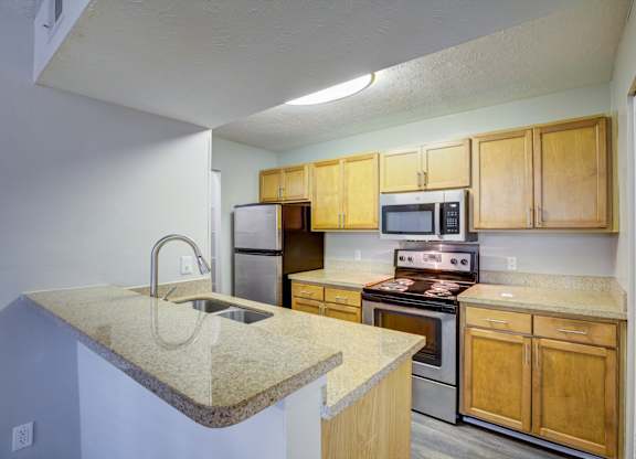 A kitchen with wooden cabinets and a granite countertop.