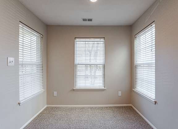 A room with a window and blinds.