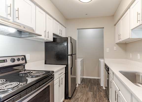 A kitchen with black appliances and white cabinets.