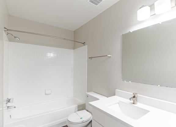 A white bathroom with a toilet, sink, and bathtub.