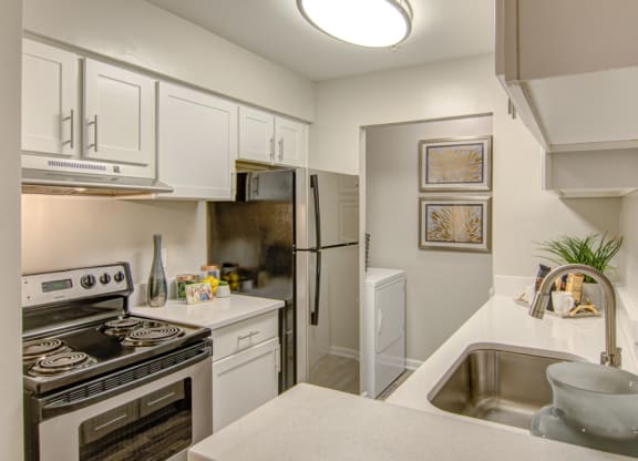 a kitchen with white cabinetry and stainless steel appliances at Hunters Chase Apartments, Virginia