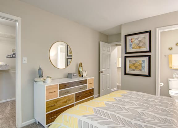 a bedroom with a bed and a dresser with a mirror on top of it at Hunters Chase Apartments, Midlothian