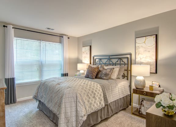 a bedroom with a bed and two night stands with lamps at Hunters Chase Apartments, Virginia,23112