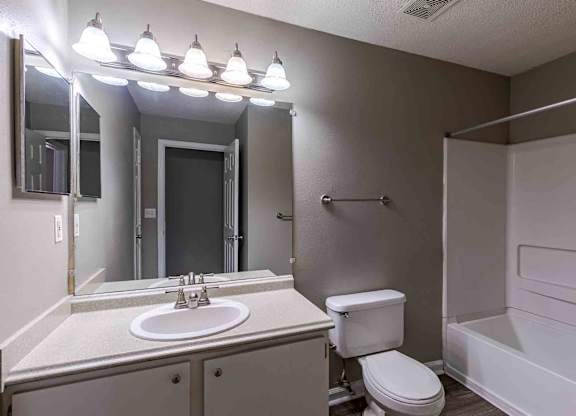 A bathroom with a white sink, toilet, and bathtub.