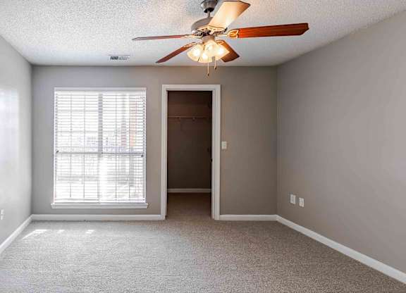 A room with a ceiling fan and a door.
