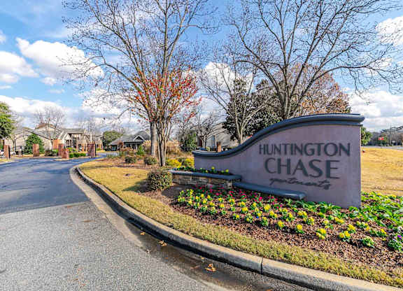 A street view of Huntington Chase with a sign and trees.
