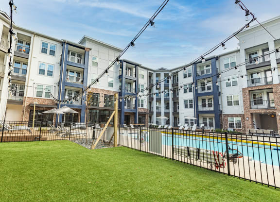an apartment building with a swimming pool and a fenced in yard at The Louis Apartment Flats, Kentucky, 40241