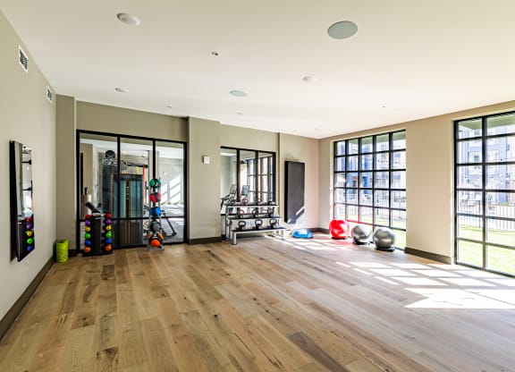 a workout room with a wood floor and large windows at The Louis Apartment Flats, Louisville, KY, 40241