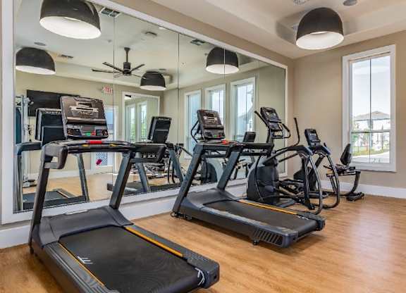 A gym with treadmills and elliptical machines.