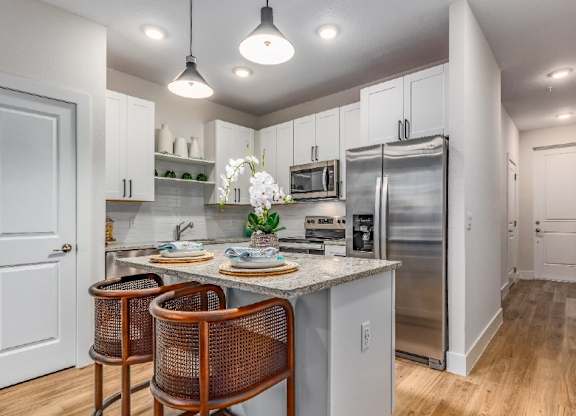 A kitchen with a table and chairs in front of a sink.
