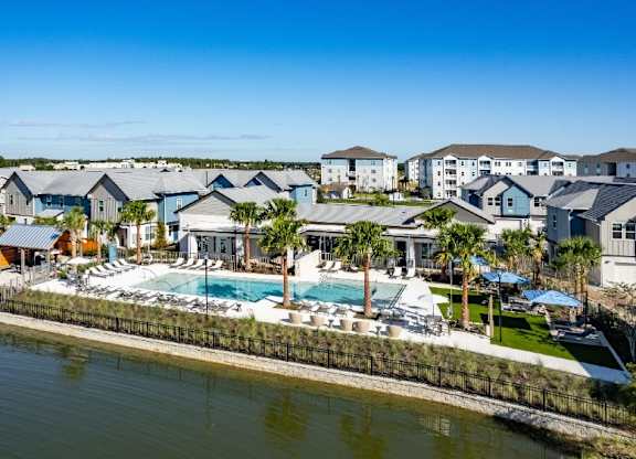 A row of houses with a pool in front of them.