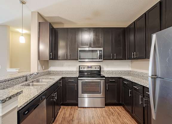 A kitchen with black cabinets and stainless steel appliances.