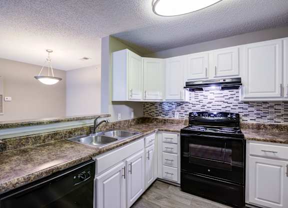 A kitchen with black appliances and granite countertops.