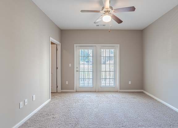 A room with a ceiling fan and a carpeted floor.
