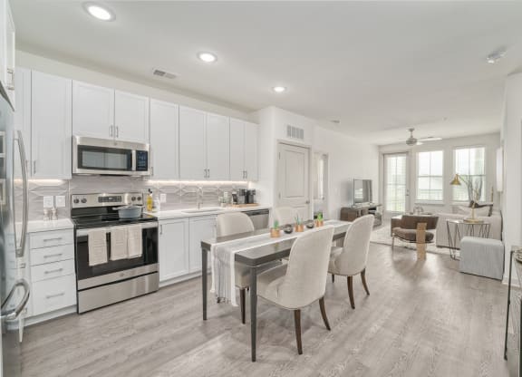 a kitchen with white cabinets and a table with chairs