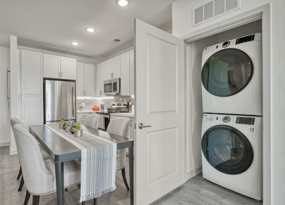 a white laundry room with a washing machine and a sink