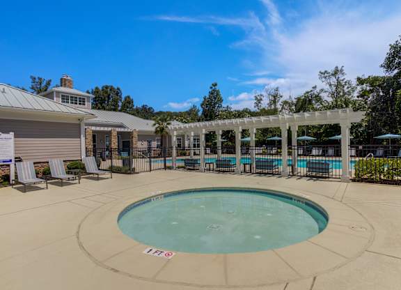 A round above ground pool with a white fence around it.