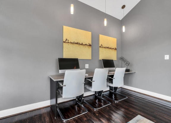 a desk with four computers in a room with gray walls and a hardwood floor at Misty Ridge Apartments, Woodbridge Virginia