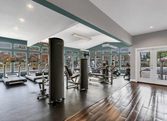 a gym with exercise equipment and a glass door with a view of a parking lot at Misty Ridge Apartments, Woodbridge, VA