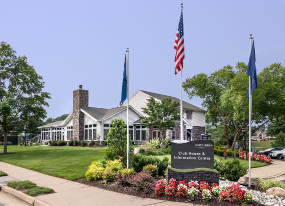 a building with an american flag and a sign in front of it at Misty Ridge Apartments, Virginia