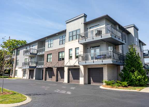 A large apartment building with a parking lot in front.