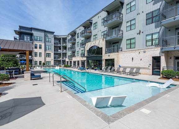 A large swimming pool in front of apartment buildings.