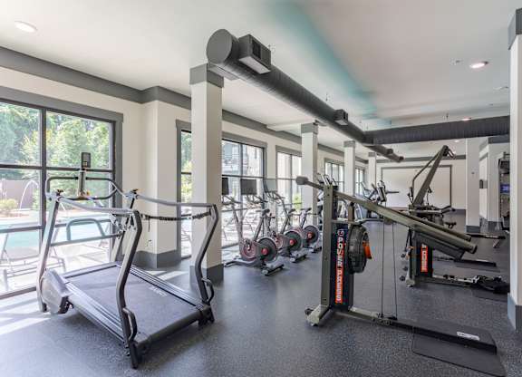 A gym with treadmills, weights, and exercise equipment.