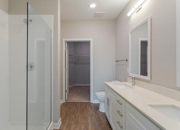 A bathroom with a walk-in shower, toilet, and sink.
